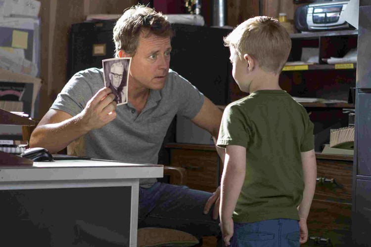 Todd (Greg Kinnear) shows Colton (Connor Corum) a picture of 'Pops' his grandfather in TriStar Pictures' HEAVEN IS FOR REAL.